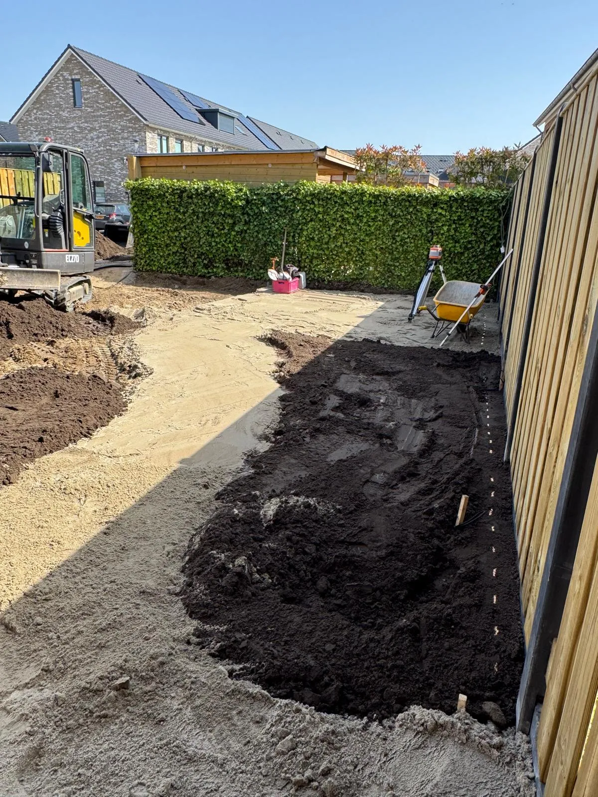 Uitgegraven tuin met zand voor de paden en grond voor de plantvakken