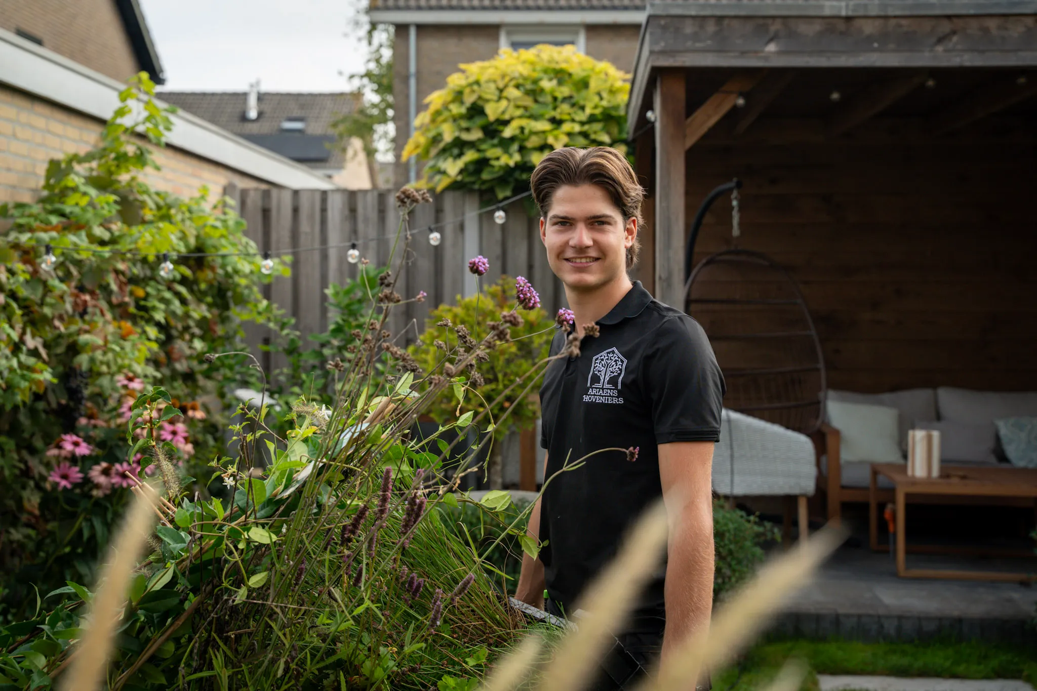Jaap Ariaens tussen de beplanting in een tuin